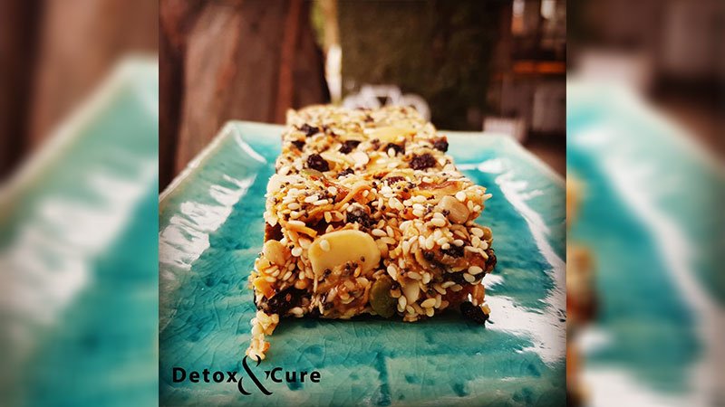 What is Chia Seeds Good For? bite size chia seed muesli bar on a turquoise cafe plate with an gold fork