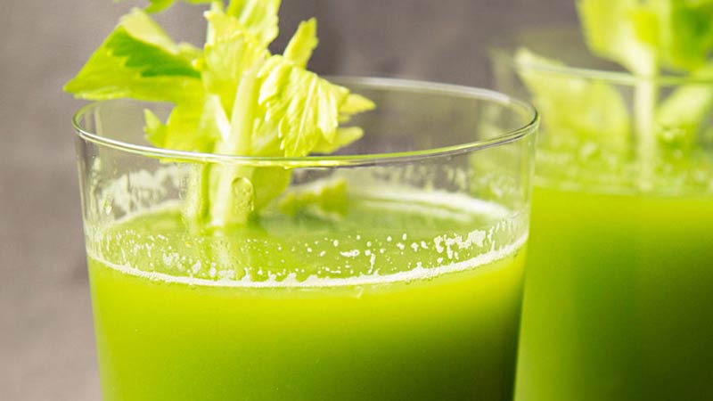 best weight loss juice recipe - www.detoxandcure.com - green juice in a tall glass with a celery stick sitting in it