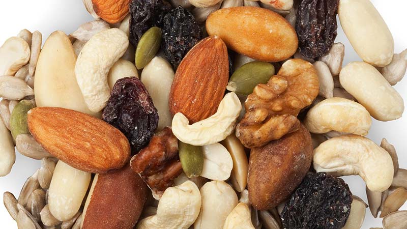 An Ancient Pulse Recipe that's Vegan and Keto Friendly - mixed dried fruit and nuts oncluding almonds, cashews, pepitas, brazil nuts, sunflower seeds, peanuts and currants on a white background