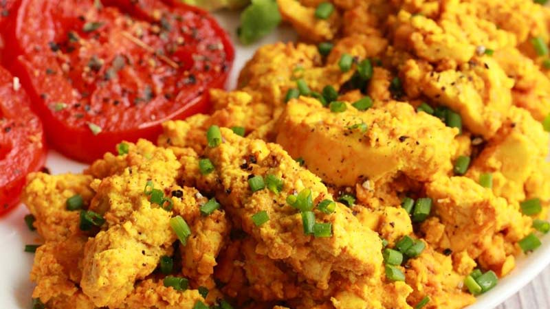 tofu scrambled eggs on a plate with tomato - Vegan-Scrambled-Eggs-made-Simple-and-Spicy