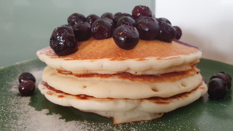 Gluten Free Blueberry Pancakes Recipe served on a green plate with a light dusting of fine lakanto